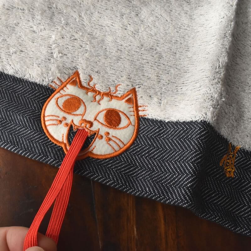 オレンジ顔のミミケルレロレロ紐付き今治タオル